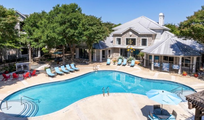 Shimmering resort-style pool a swimming pool with chairs and umbrellas next to a house